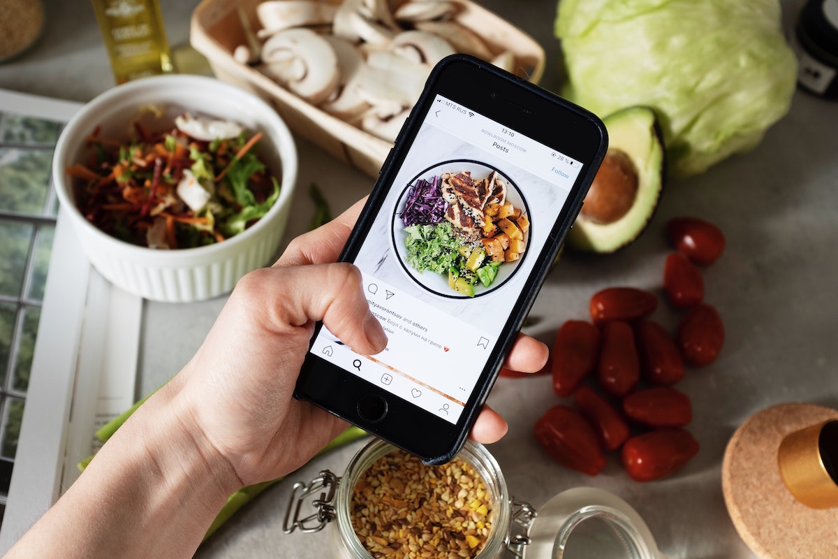 person taking photo of food for instagram; blog: boosting your brand on instagram