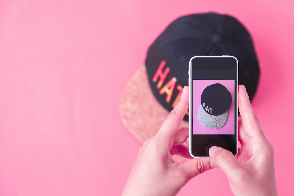 young women taking photo to hat with cell telephone or smartphone digital camera for Post to sell Online on the Internet . Customise pastel bright colors tone; blog: shopping experiences on instagram