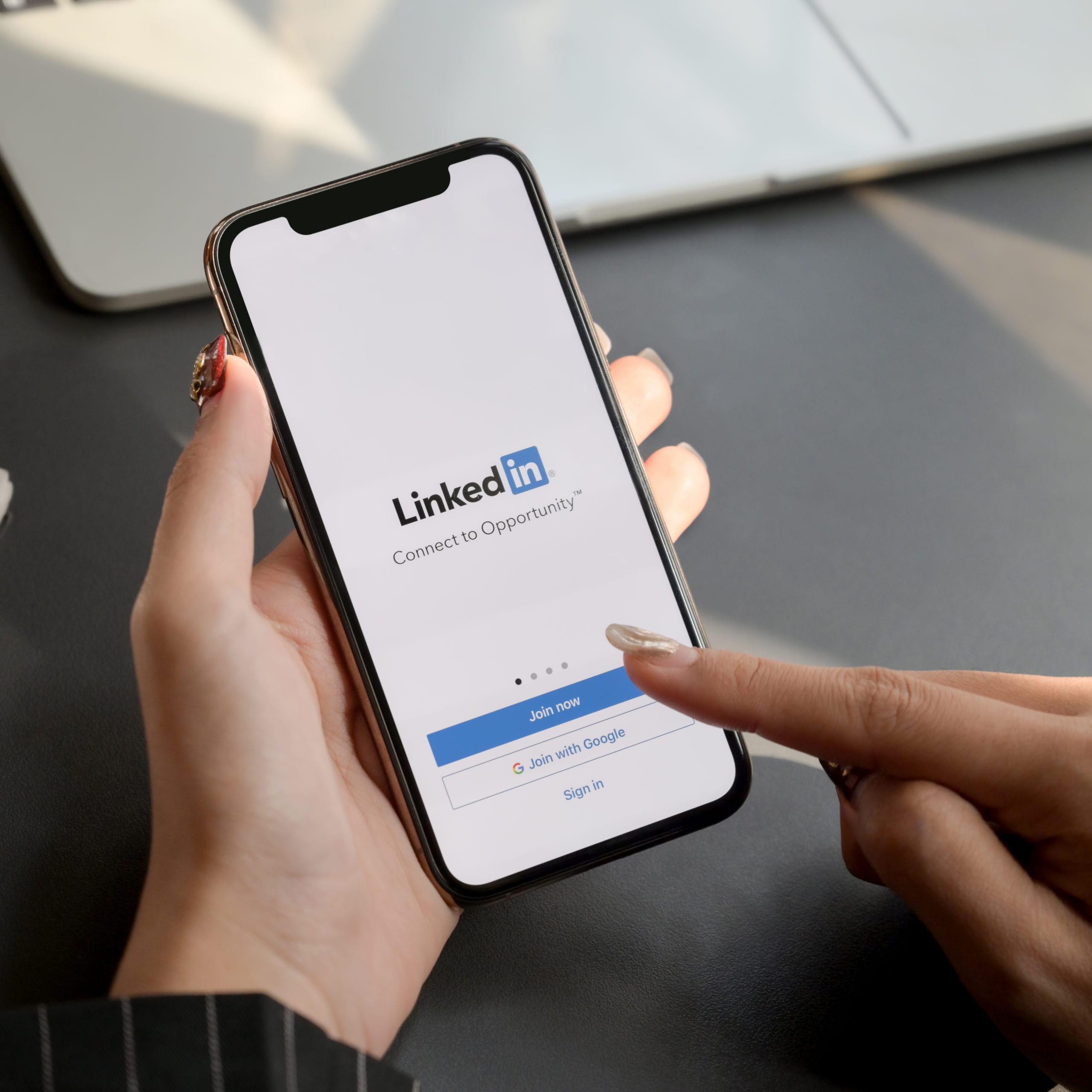 CHIANG MAI, THAILAND - JANUARY 31, 2020 : female touching iPhone with LinkedIn screen. LinkedIn helps build portfolio and look for a new job; Blog: updating your personal linkedin