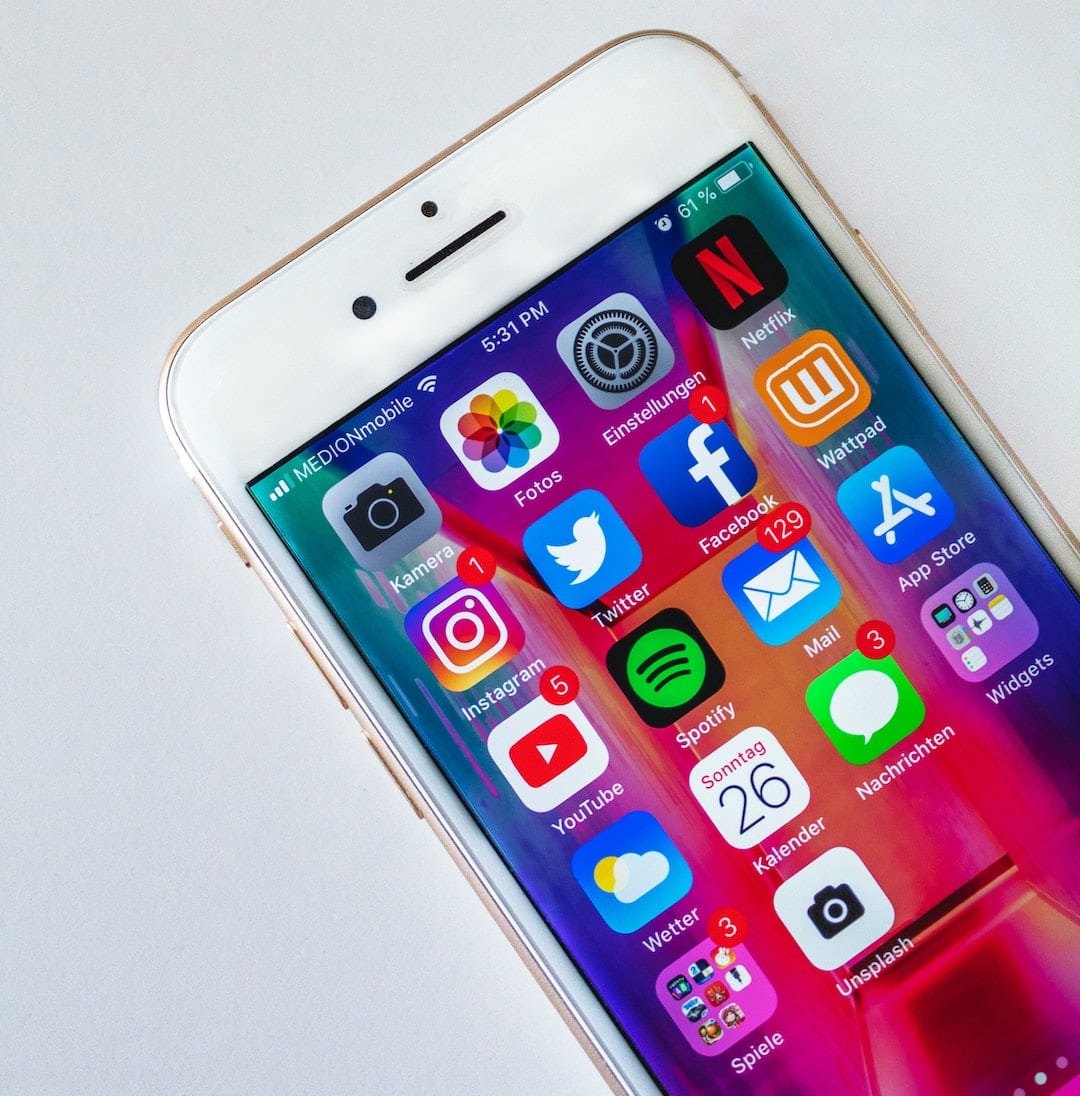 white iphone with social media app icons on screen; blog: social media trends for 2021