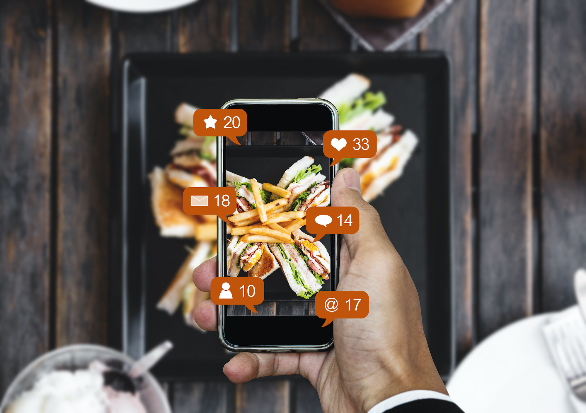 Taking food photograph by mobile smart phone, and sharing on social media, social network with notification icons; blog: Tips for Marketing Your Restaurant on Social Media
