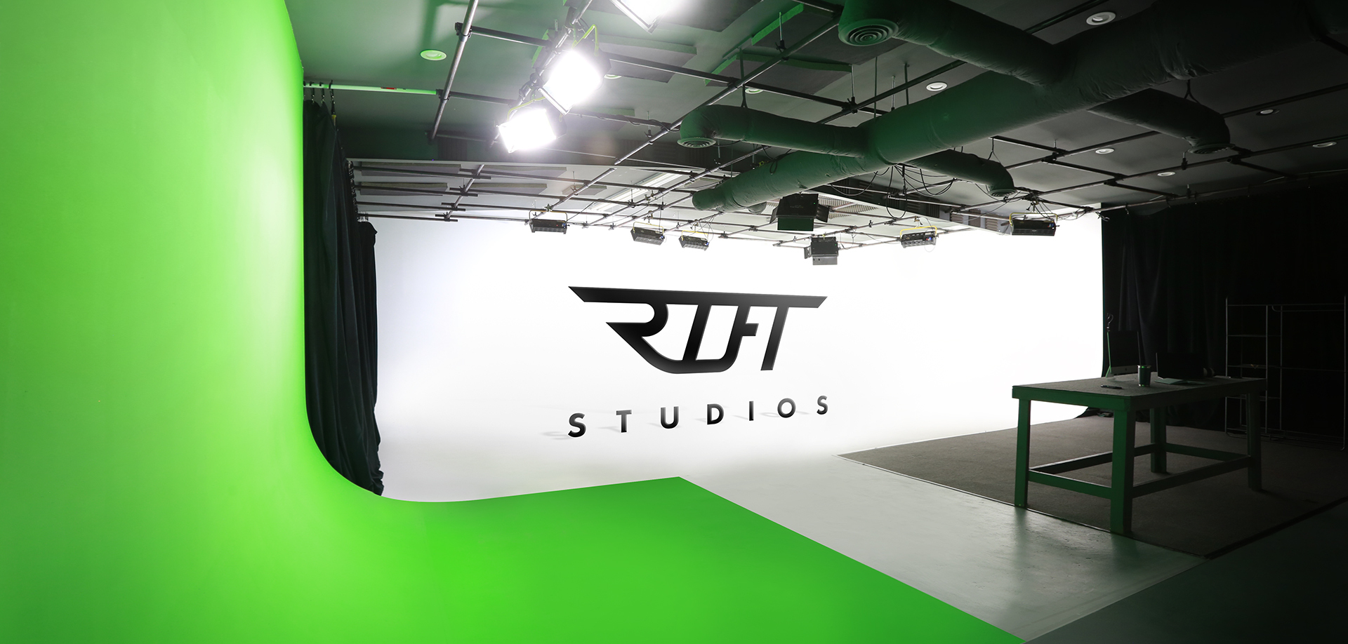 photo of Rift Studios green and white cyc wall with Rift logo on white wall