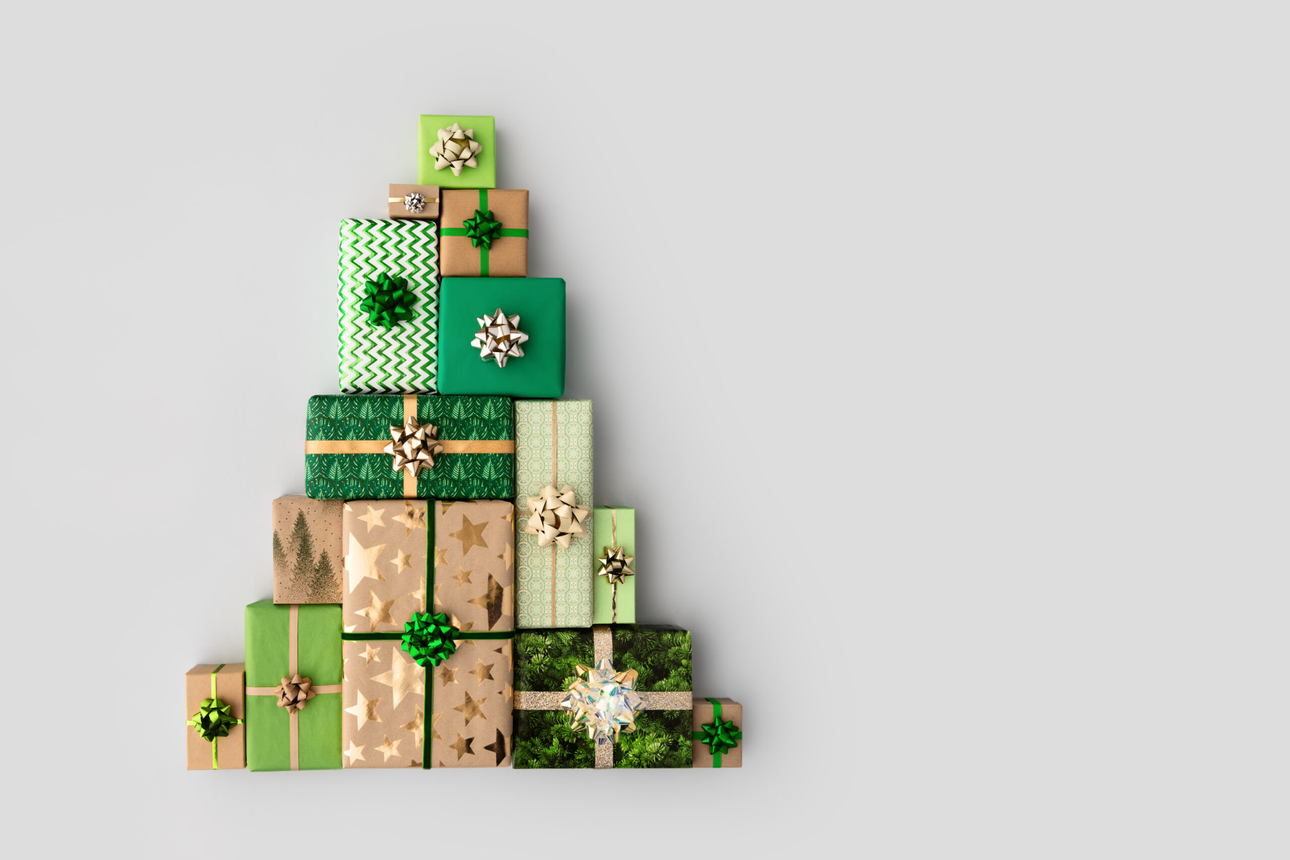 Christmas gift boxes laid out in the shape of a Christmas tree, overhead view to represent a 2024 gift guide